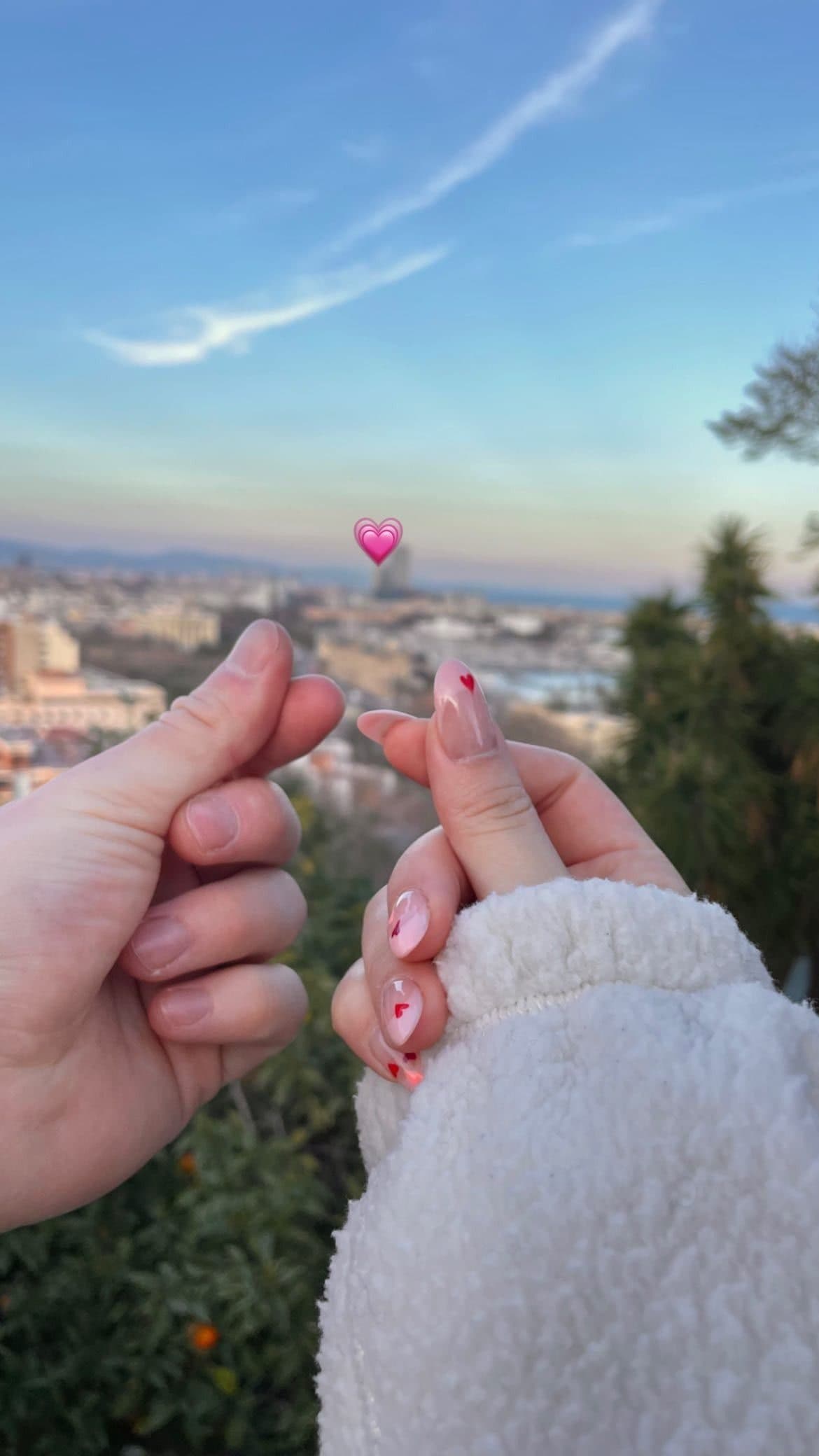 Two hands reaching to touch in front of a city view