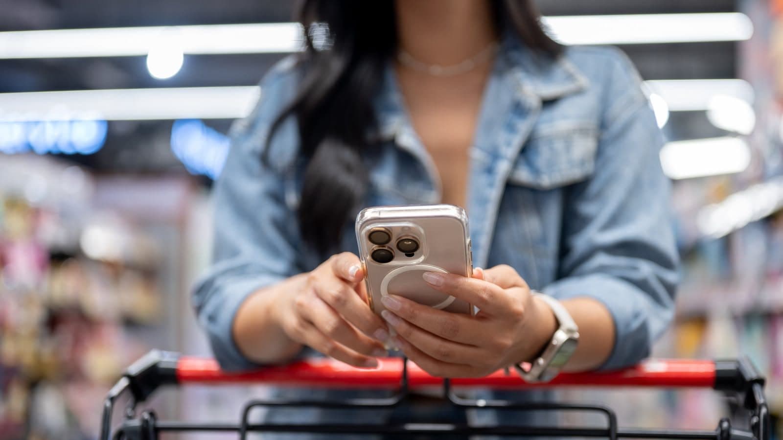 A phone held up in a grocery aisle while shopping