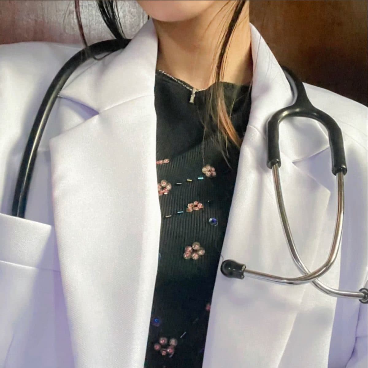 A student wearing a white coat with a stethoscope