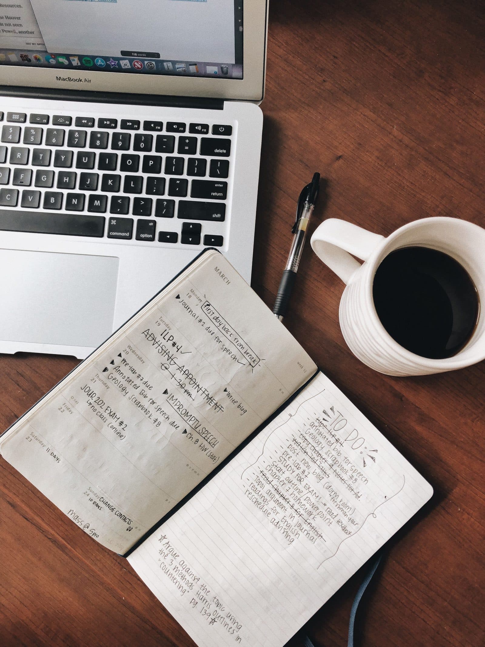 A notebook of startup ideas open on a desk next to a laptop