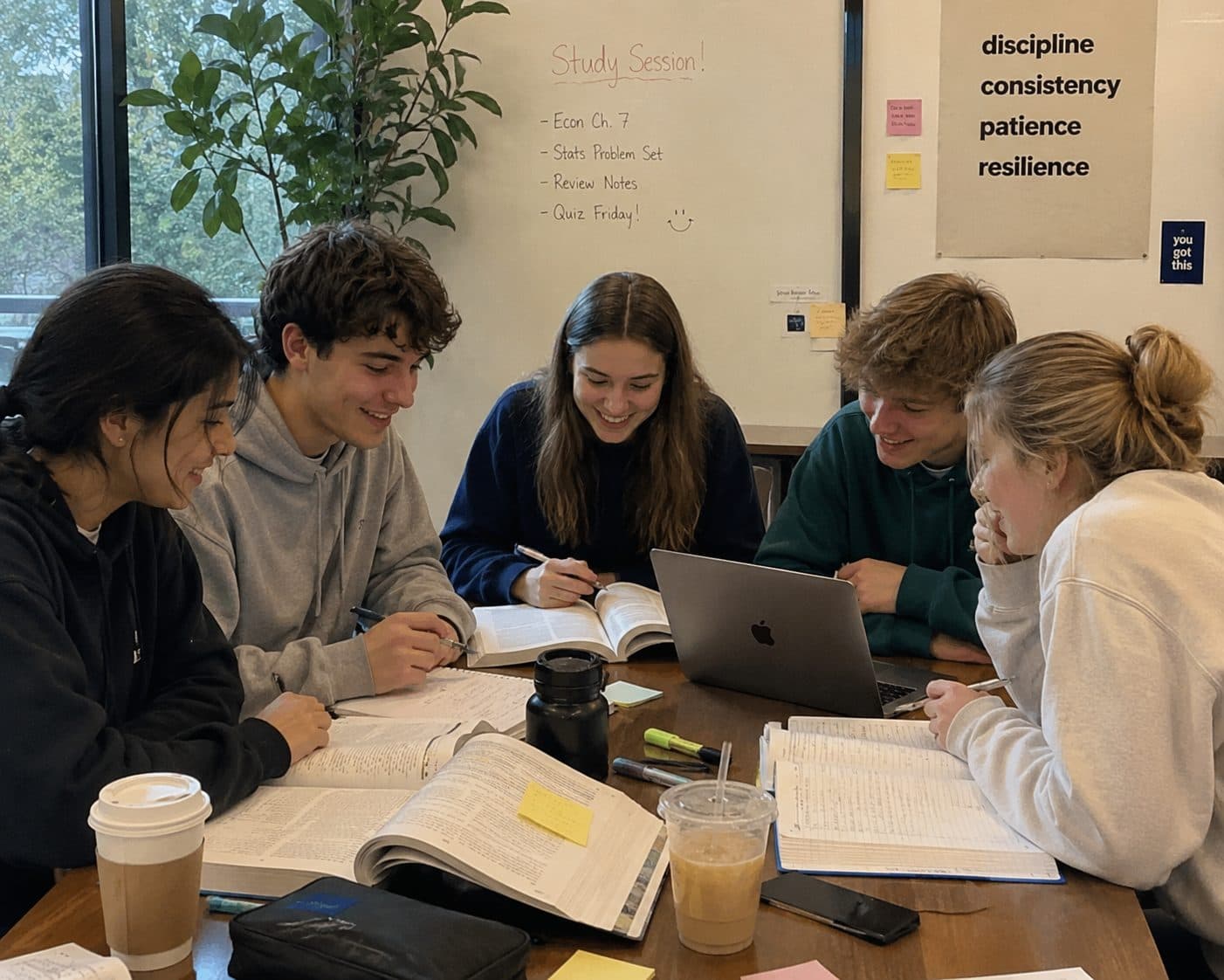 Five students laughing together during a group study session
