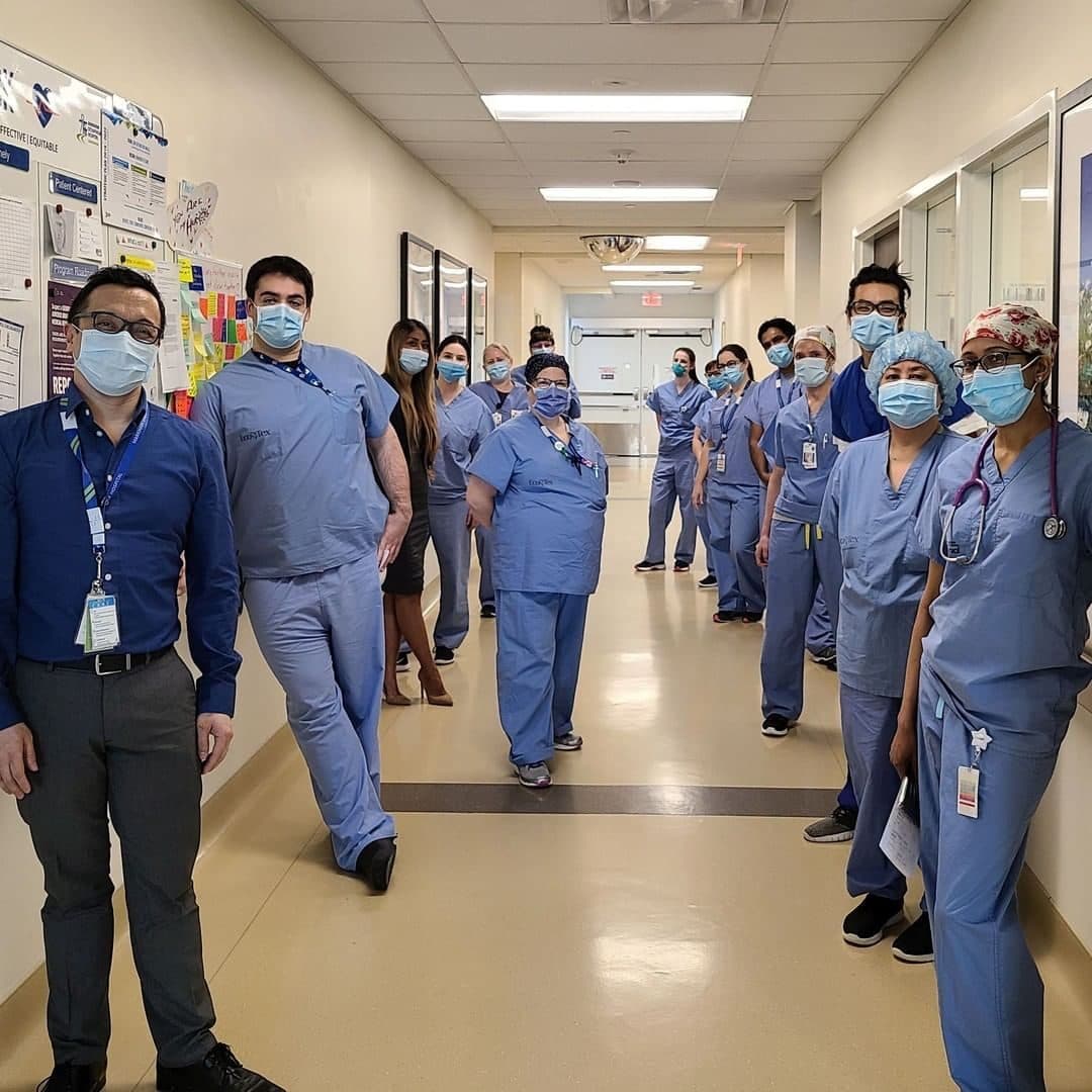 A group of staff in scrubs in a hospital hallway
